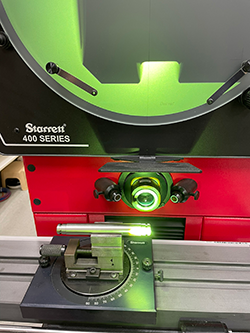 image of a comparator which magnifies a part to get a more accurate measurement.